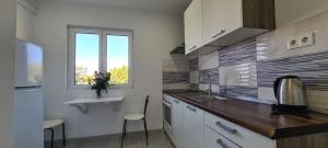 a kitchen with a counter and a sink and a window at Apartments Ana i Ante Punta in Milna