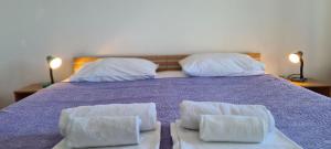 a bed with two white towels on top of it at Apartments Ana i Ante Punta in Milna