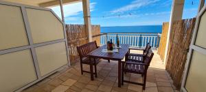 a table and chairs on a balcony with a view of the ocean at Apartments Ana i Ante Punta in Milna