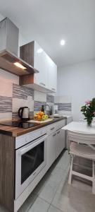 Apartments Ana i Ante Punta في ميلنا: مطبخ فيه ادوات بيضاء وطاولة فيه