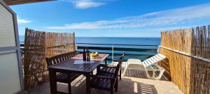 a table on a balcony with a view of the ocean at Apartments Ana i Ante Punta in Milna