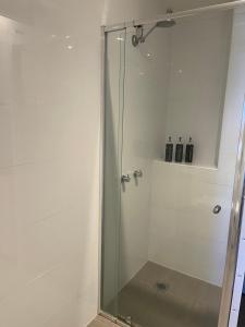 a shower with a glass door in a bathroom at Cooma Hotel in Cooma