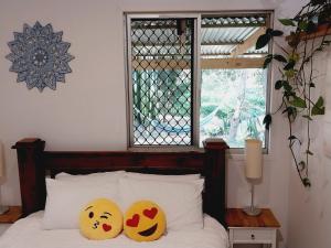 two pillows on a bed with a window at Oasis at Burringbar waterfront holiday 