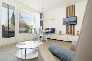 a living room with a couch and a table at Sol Mare 25 Ostseezeit in Kellenhusen