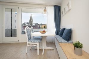 a white table and chairs in a room with a window at Sol Mare 25 Ostseezeit in Kellenhusen