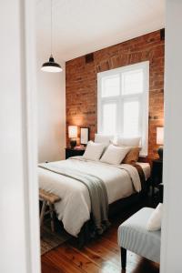 1 dormitorio con 2 camas y pared de ladrillo en The Pioneer - A Luxurious, Federation Home. en Dubbo
