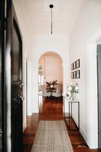 un pasillo con paredes blancas y una mesa en The Pioneer - A Luxurious, Federation Home. en Dubbo