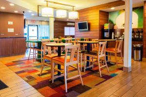 ein Restaurant mit Tischen und Stühlen auf einem bunten Teppich in der Unterkunft Fairfield Inn by Marriott Ponca City in Ponca City