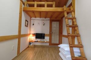 a bedroom with a wooden bunk bed with a ladder at Gangneongjeon Hanok Stay in Jeonju