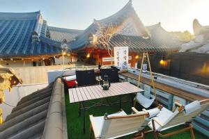 a table and chairs on the roof of a building at Gangneongjeon Hanok Stay in Jeonju