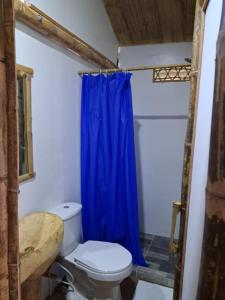 uma casa de banho com um WC e uma cortina de chuveiro azul em Eco Hotel Finca El Encanto em Pereira