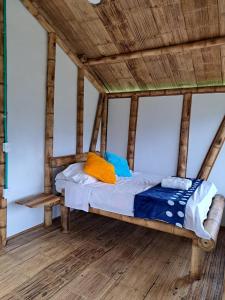 Eco Hotel Finca El Encanto في بيريرا: سرير في غرفة ذات سقف خشبي
