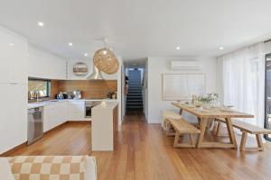 Una cocina y un comedor con una mesa de madera. en Island Surf House, en Cape Woolamai