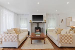 Una sala de estar con dos sofás y una chimenea. en Island Surf House, en Cape Woolamai
