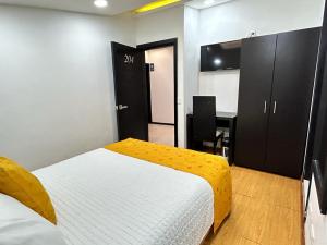 1 dormitorio con cama y escritorio. en Hotel Lagos Latin America, en Pasto