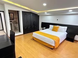 a bedroom with a large bed with a yellow blanket at Hotel Lagos Latin America in Pasto +24 photos
