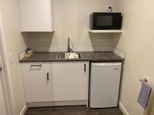 a small kitchen with a sink and a microwave at Riverlea Motel in Gore