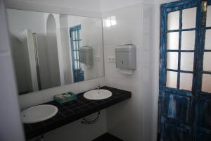 Baño con 2 lavabos y espejo en Wake up in Tarifa Hostel & Restaurant Lounge, en Tarifa