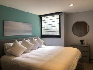 a bedroom with a bed with white pillows and a window at Pegado a la Condesa gran ubicación King size in Mexico City