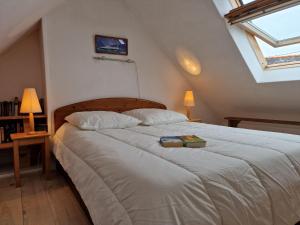 ein Schlafzimmer mit einem Bett mit zwei Büchern darauf in der Unterkunft Set of 2 houses in Plougasnou, 300 m from the coast in Plougasnou
