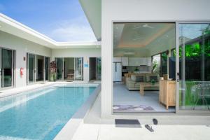 タラーンにあるAreeca Private pool villasのスイミングプールとリビングルーム付きの家