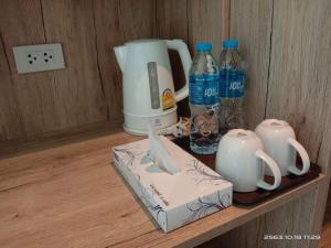 a shelf with a coffee maker and bottles of water at Areeca Private pool villas in Thalang