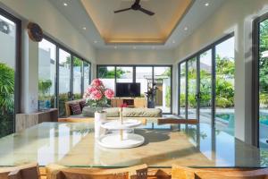 a living room with glass walls and a ceiling at Areeca Private pool villas in Thalang