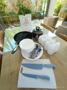 Areeca Private pool villas في تالانغ: طاولة مع سكين وأطباق وأواني