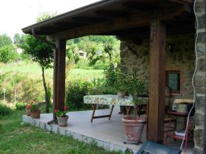 um pátio com uma mesa e vasos de plantas em Alluring Holiday Home in Canossa with Pool Garden Barbecue em Mulazzo