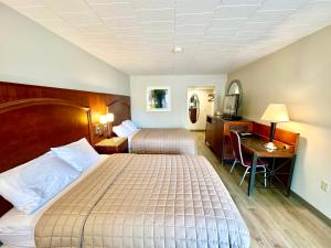 a hotel room with two beds and a desk at Inn of Sheboygan in Sheboygan