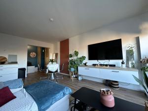 uma sala de estar com uma cama e uma televisão de ecrã plano em LILLE Appart Cosy 68m2 lumineux avec balcon - garage prive em Lille