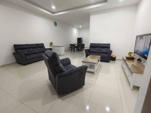 a living room with two couches and a table at Sakura homestay 5 bedrooms - Spring Lopeng 14 pax in Miri