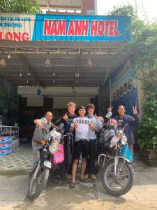 a group of men standing in front of a motorcycle at Nam Anh Hotel in Phong Nha