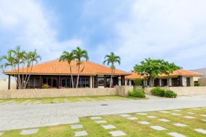 um edifício com telhado laranja e palmeiras em Oriental Villa - Vacation STAY 09167v em Ishigaki