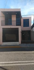 a white house with a gate on the side of a street at Ola in Aguascalientes