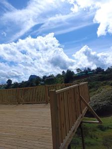 Una terraza de madera con una valla de madera y un cielo nublado. en Apartamento La bonita guatape, en Guatapé 18 fotos más