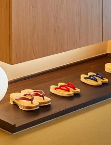 cztery pary klapek siedzących na półce w obiekcie Tomonoya Signature Ryokan Namhae w mieście Namhae