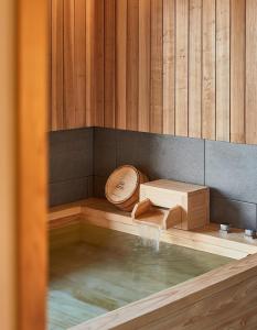 a pool of water in a sauna with a water fall at Tomonoya Signature Ryokan Namhae in Namhae