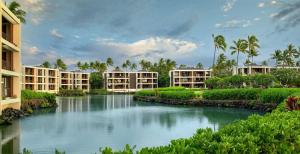 a river in front of some apartment buildings at Mauna Lani Terrace G102 - Lagoon View Terrace Suite - Upscale Luxury Waterfront in Waikoloa