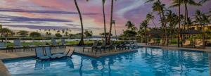 a pool at a resort with chairs and palm trees at Mauna Lani Terrace G102 - Lagoon View Terrace Suite - Upscale Luxury Waterfront in Waikoloa