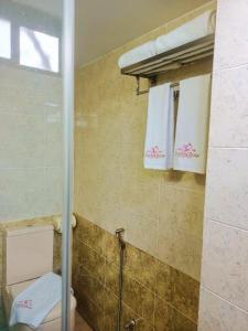 łazienka z toaletą i 2 białymi ręcznikami w obiekcie Hotel Crystal Rose - Sylhet w mieście Srihotto