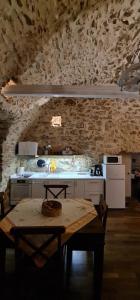 a kitchen with a table and a stone wall at Olive oil mill in Kokkala