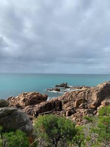 a view of the ocean with rocks and the water at Panda's Patch Dunsborough in Dunsborough