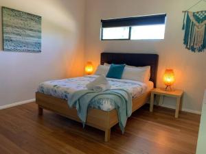 a bedroom with a bed with two lamps on it at Panda's Patch Dunsborough in Dunsborough