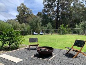 two chairs and a fire pit in a yard at Panda's Patch Dunsborough in Dunsborough