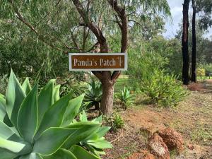 a sign on a tree in a garden at Panda's Patch Dunsborough in Dunsborough