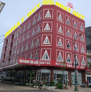 un grande edificio rosso con un cartello sopra di Nhat Quy Hotel a Tây Ninh