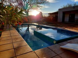 una piscina in un cortile con il tramonto di Casa - del TALAMPAYA a Villa Unión