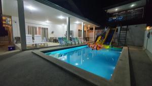 a indoor swimming pool with slides and chairs in a building at Family POOL VILLA CHAAM in Cha Am +96 photos