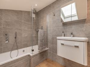 een badkamer met een douche, een wastafel en een spiegel bij The Old Haybarn in Longford